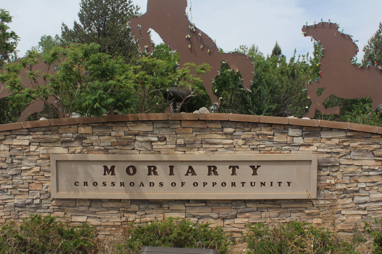 Brown brick wall with a large sign saying Moriarty Crossroads of Opportunity